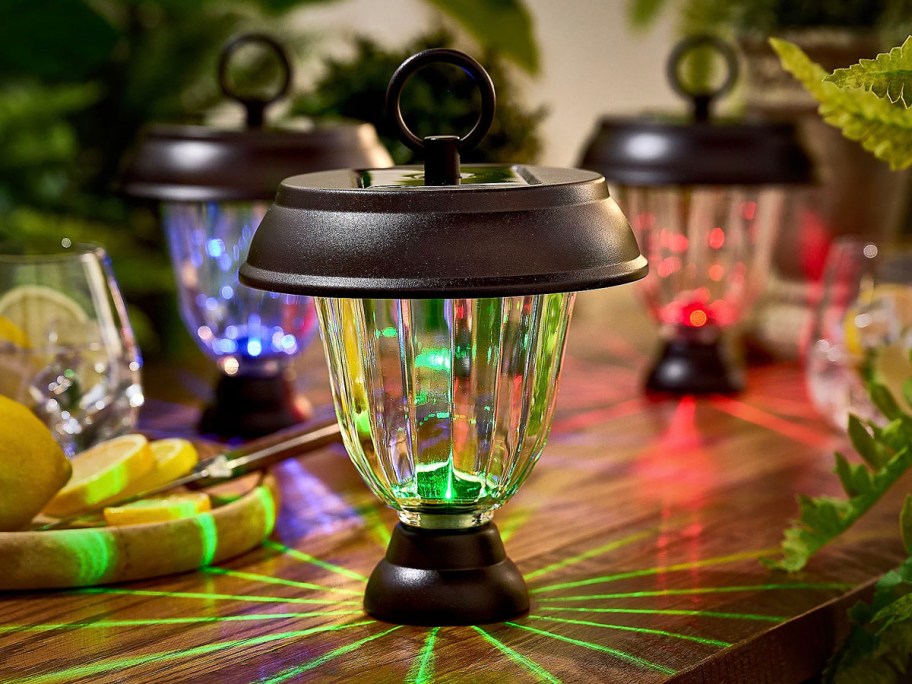 solar lights sitting on table in green, blue and red 