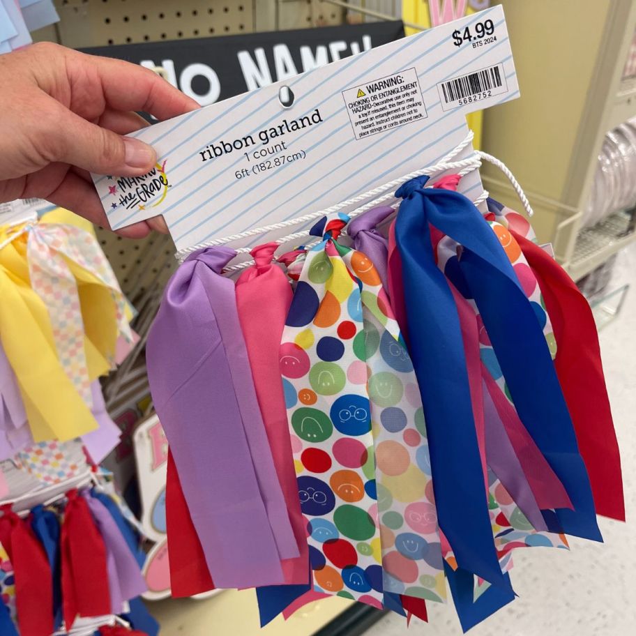 womans hand holding a pack of ribbon garland