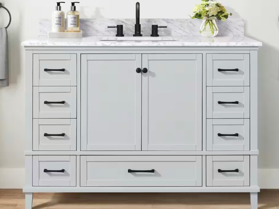 gray bathroom vanity in bathroom with flowers on top 