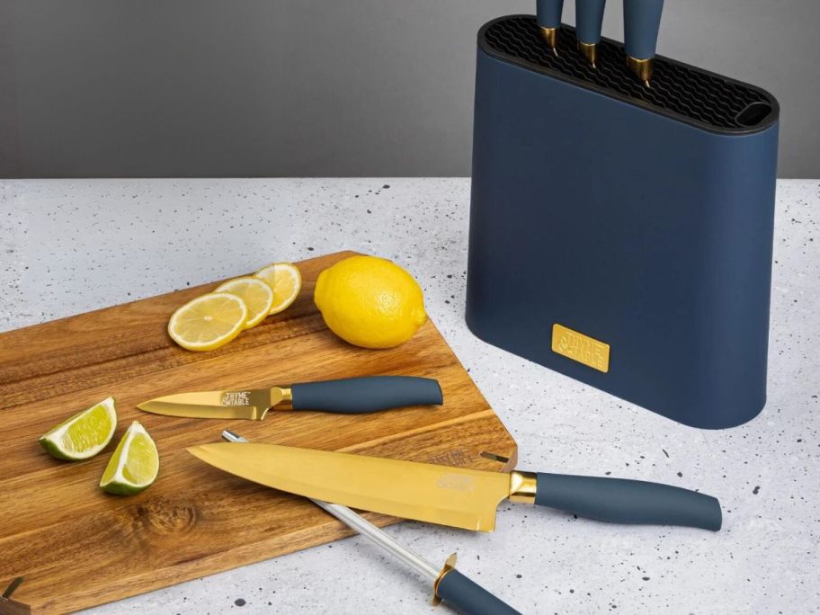 Thyme & Table 7-Piece Slim Block Knife Set with Gold Blades on counter on cutting board with lemons next to Blue Block