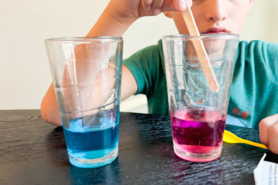 boy stirring colored water