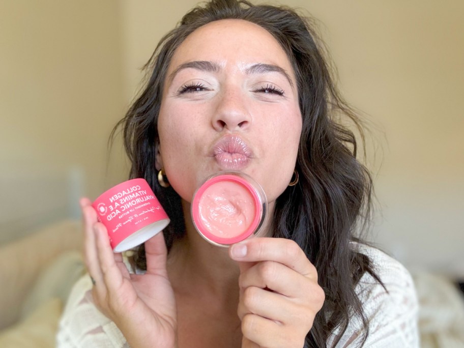 woman holding lip butter jar next to lips