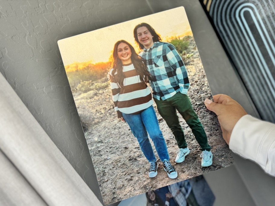 hand holding metal print on wall