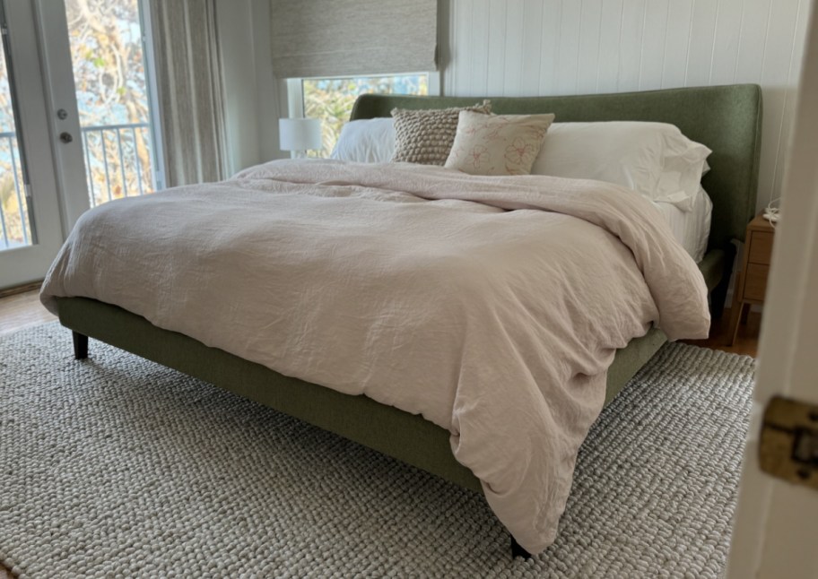 pale pink duvet on green bed