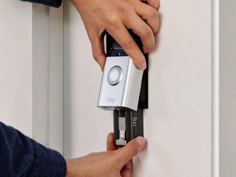 hand taking battery out of ring doorbell 3