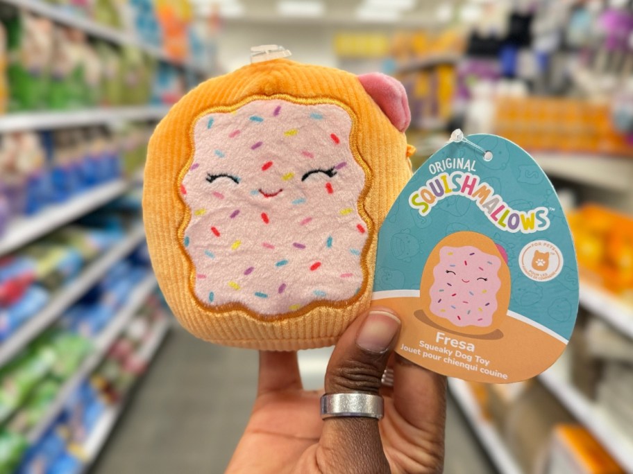 hand holding a hand holding a toaster pastry shaped Squishmallow pet toy