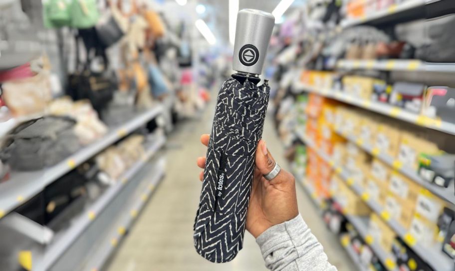 a womans hand holding a chevron print totes umbrella