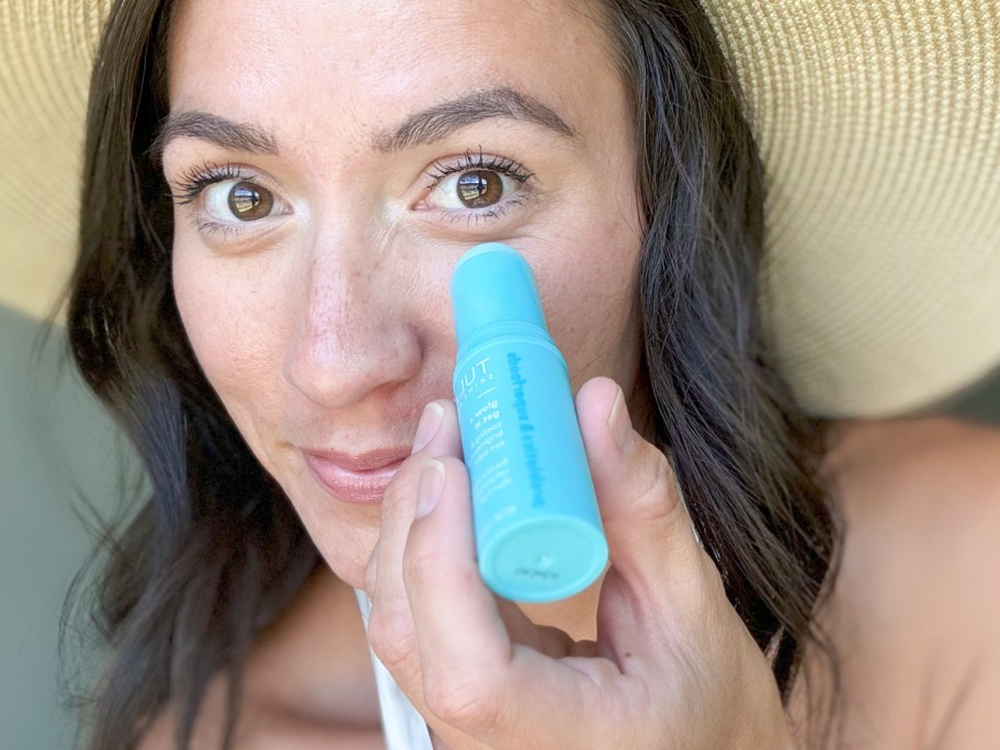 woman applying eye balm under eyes