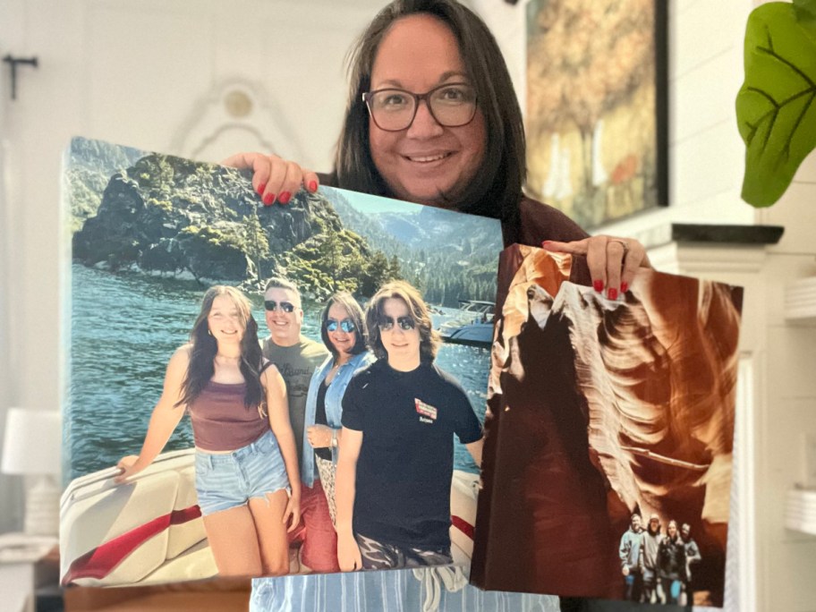 woman holding up two canvases