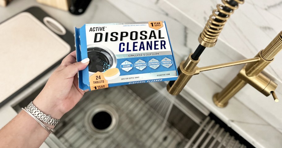 holding a box of Active Garbage Disposal Cleaner over kitchen sink