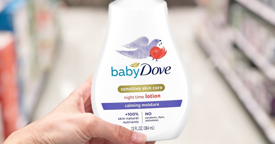 hand holding up a bottle of Baby Dove Sensitive Skin Baby Lotion in store