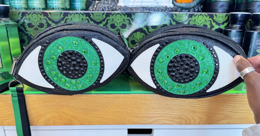 hand touching green eyeball cosmetic bag