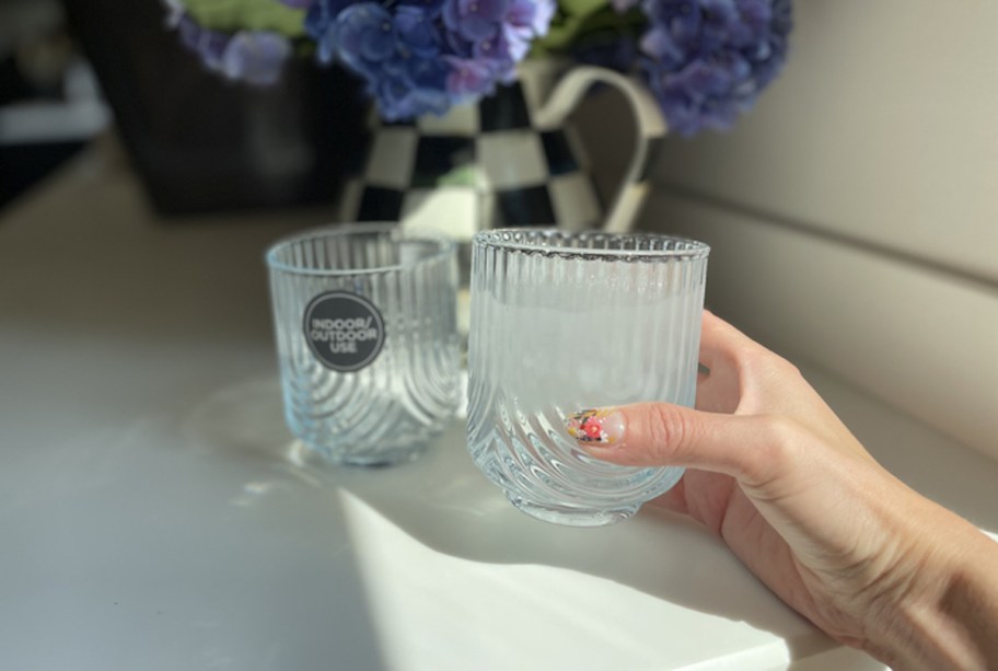 hand holding ribbed shatterproof glass on white countertop