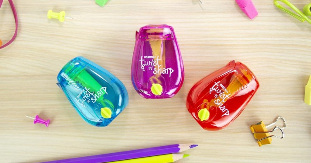 blue, pink, and orange pencil sharpeners on desk