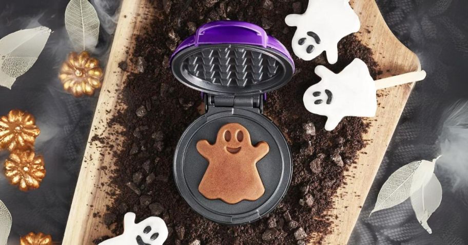 Dash Ghost Mini Waffle Maker on top of cookie pieces and ghost pops