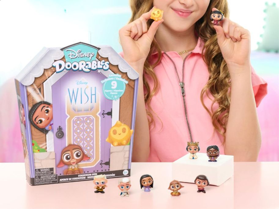 A girl playing with Disney Doorables Wish toys