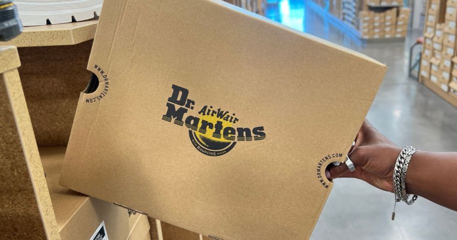 Hand pulling a dr Martens Shoe Box off a shelf