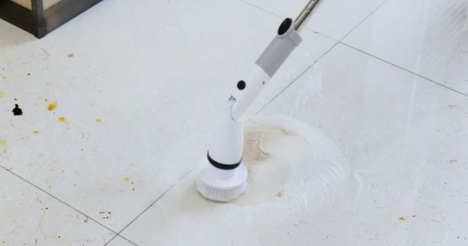 person using an electric spin scrubber on a floor