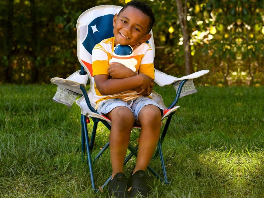 Little boy sitting in a Firefly! Kids Astronaut Camping Chair