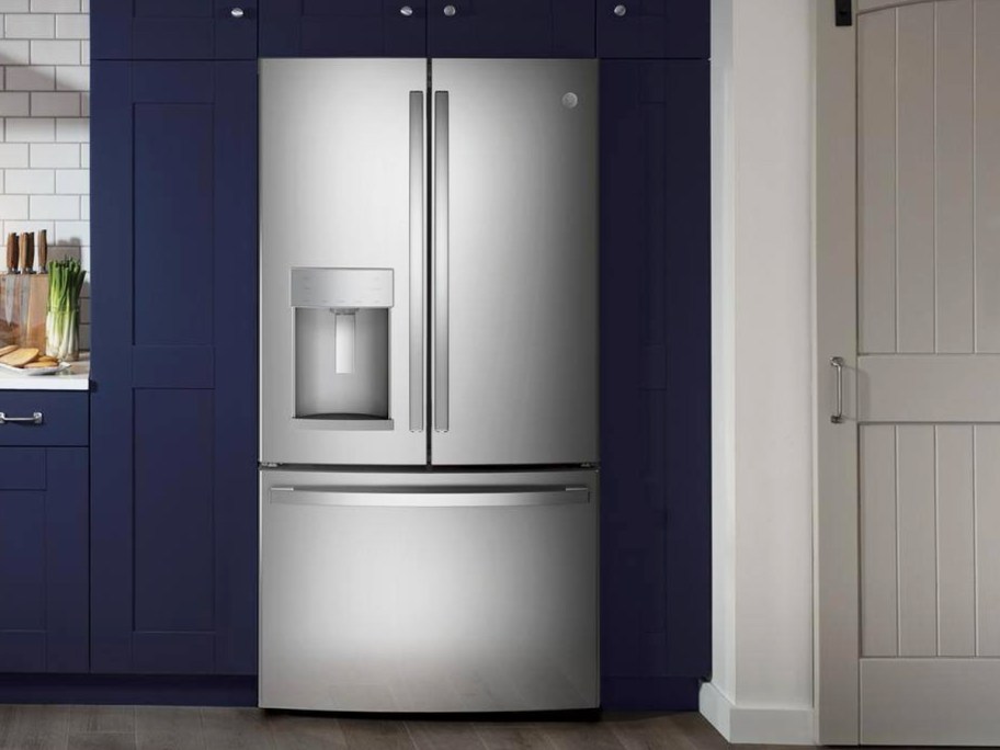 silver french door refrigerator in kitchen with blue cabinets