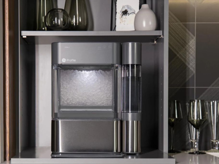 A GE Profile 2.0 Nugget Ice Maker on a counter nextt to glassware