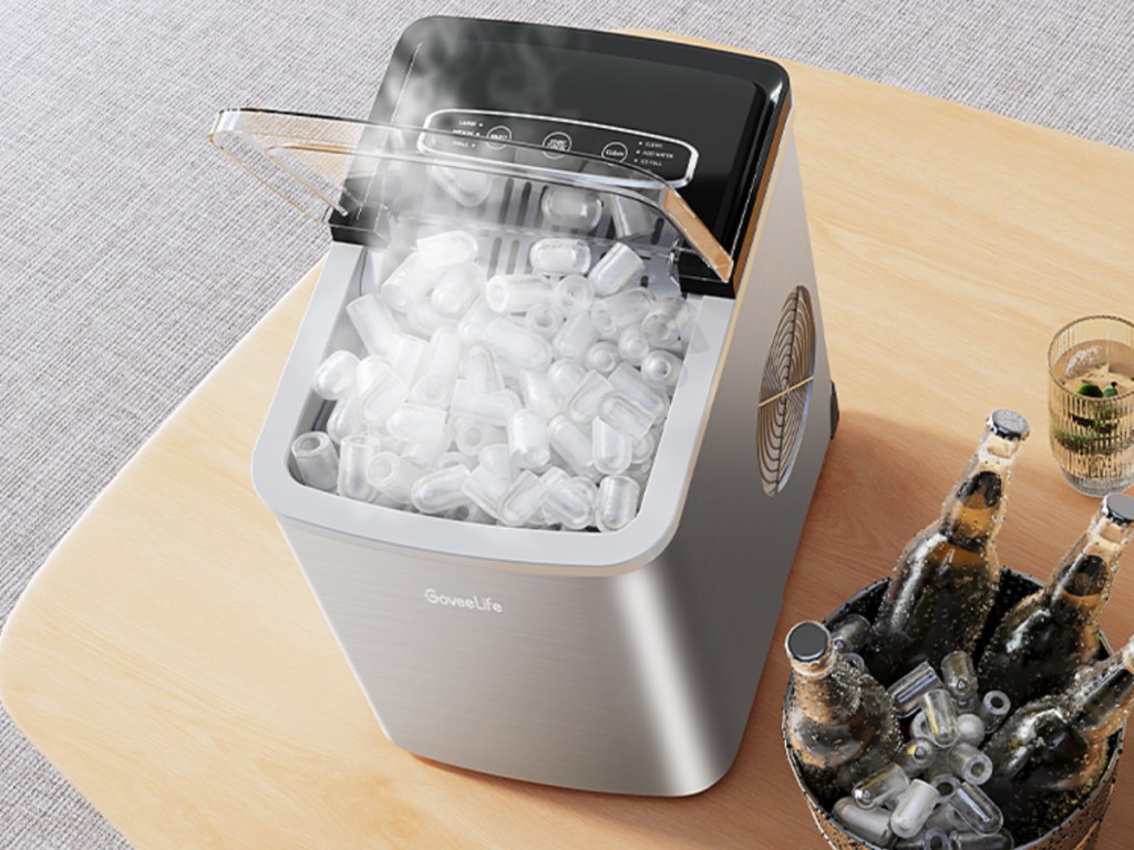 countertop ice maker on table next to bottled drinks