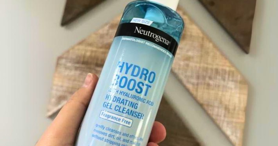 hand holding a blue bottle of Neutrogena Hydro Boost Soothing Milk Facial Cleanser