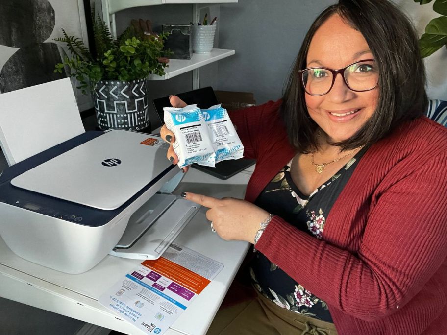 woman holding 2 ink cartridges of HP ink