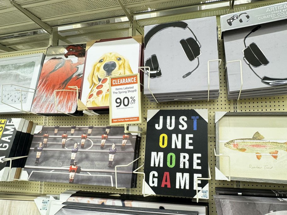 wall decor on display in store with 90% off clearance sign