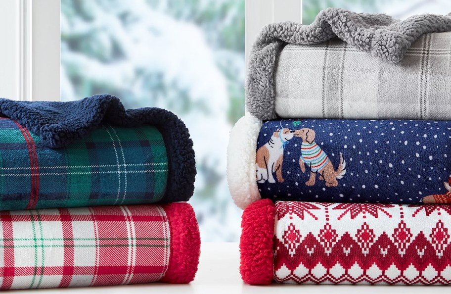 two stacks of holiday throw blankets