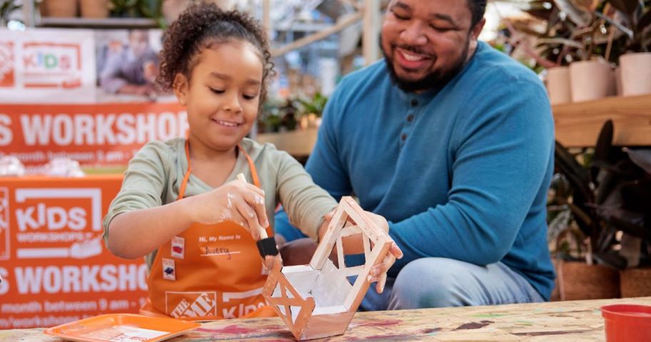 A little girl and her dad at a Home Depot Kids Wrokshop