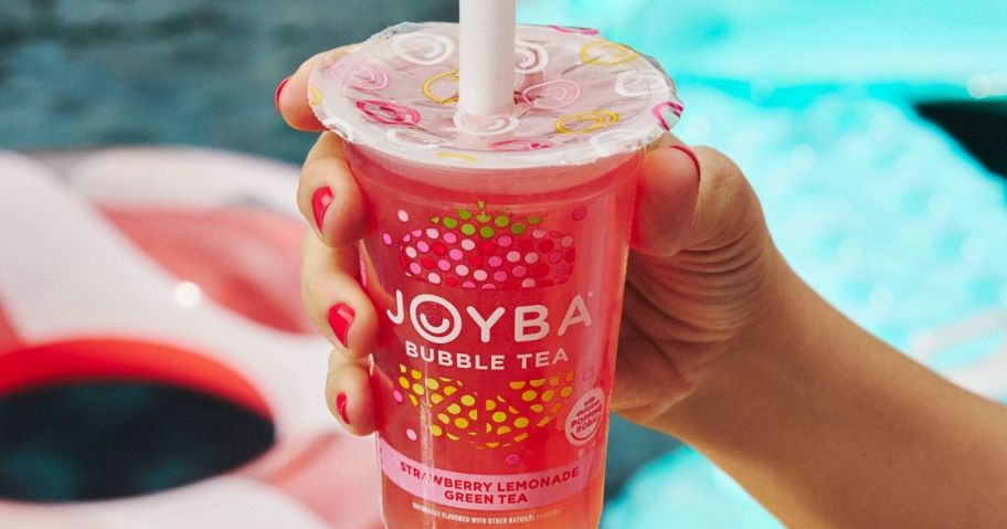 Hand holding a cup of Joya Strawberry Lemonade Bubble Tea