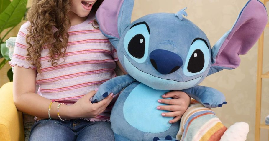 Girl holding a jumbo stitch plush