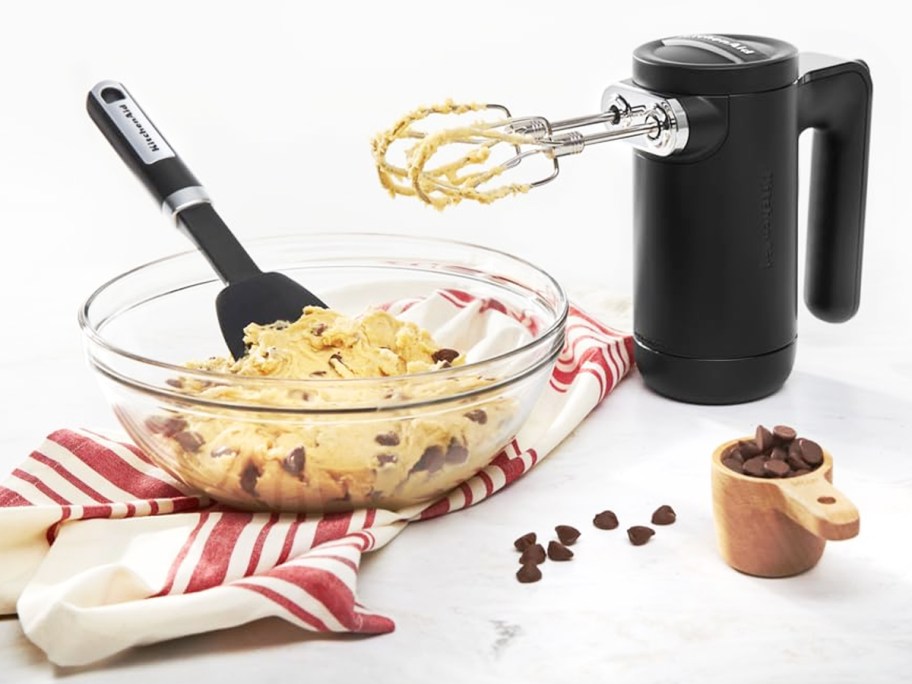 black kitchenaid mixer next to bowl of cookie dough