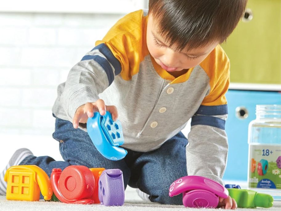 Little boy playing with a Learning Resources Snap-n-Learn Shape Snails