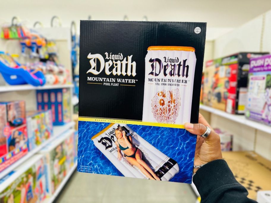 A person holding a Liquid Death pool float in a box