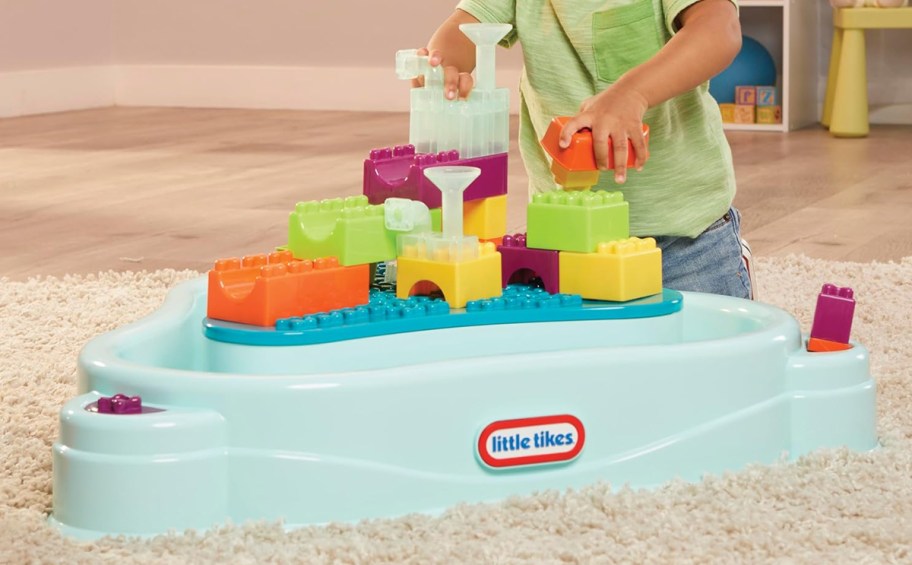 boy playing with Little Tikes Build & Splash Water Table on floor indoors