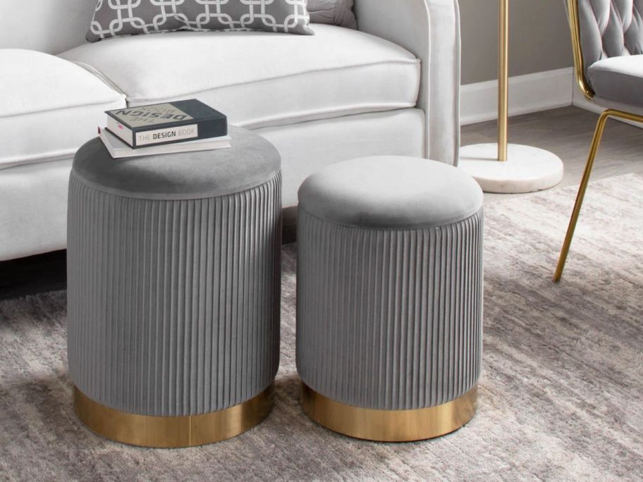 a set of 2 velvet storage ottomans on a rug in a living room