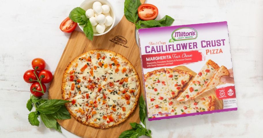 A cutting board with a Milton's Cauliflower Pizza in Margherita 4 cheese