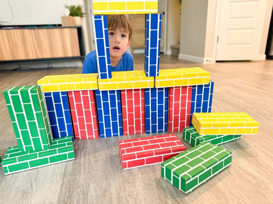 boy playing with giant cardboard bricks