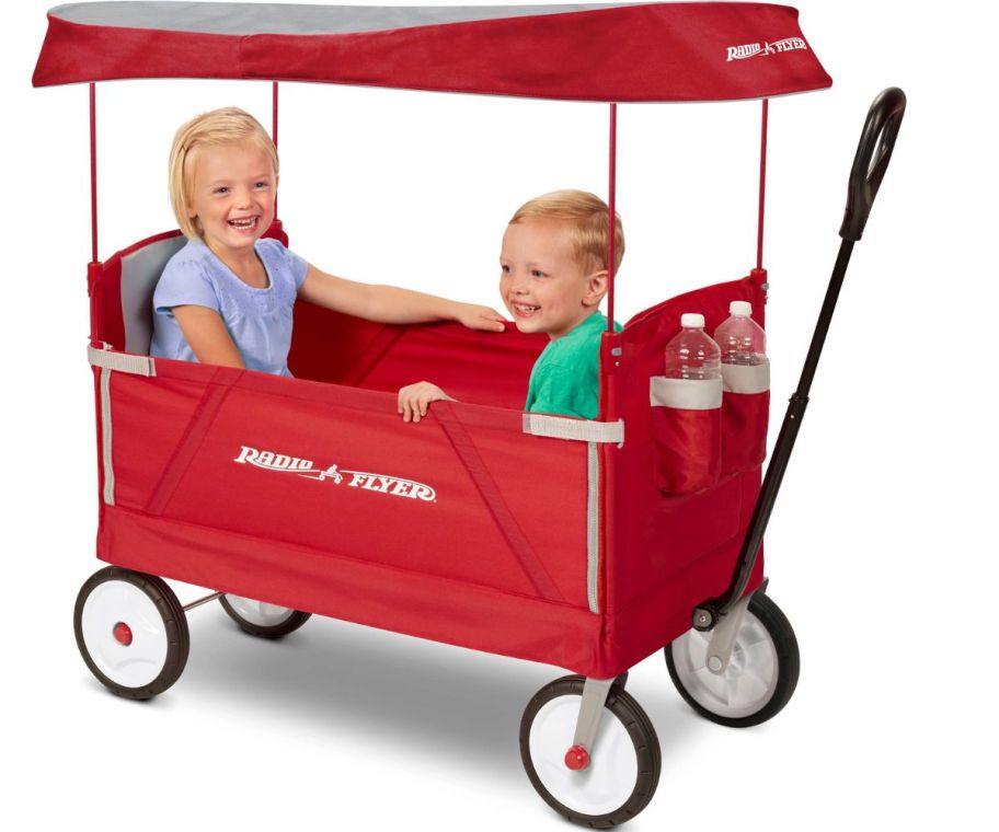 2 little kids sitting in a Radio Flyer EZ Fold Wagon with Canopy