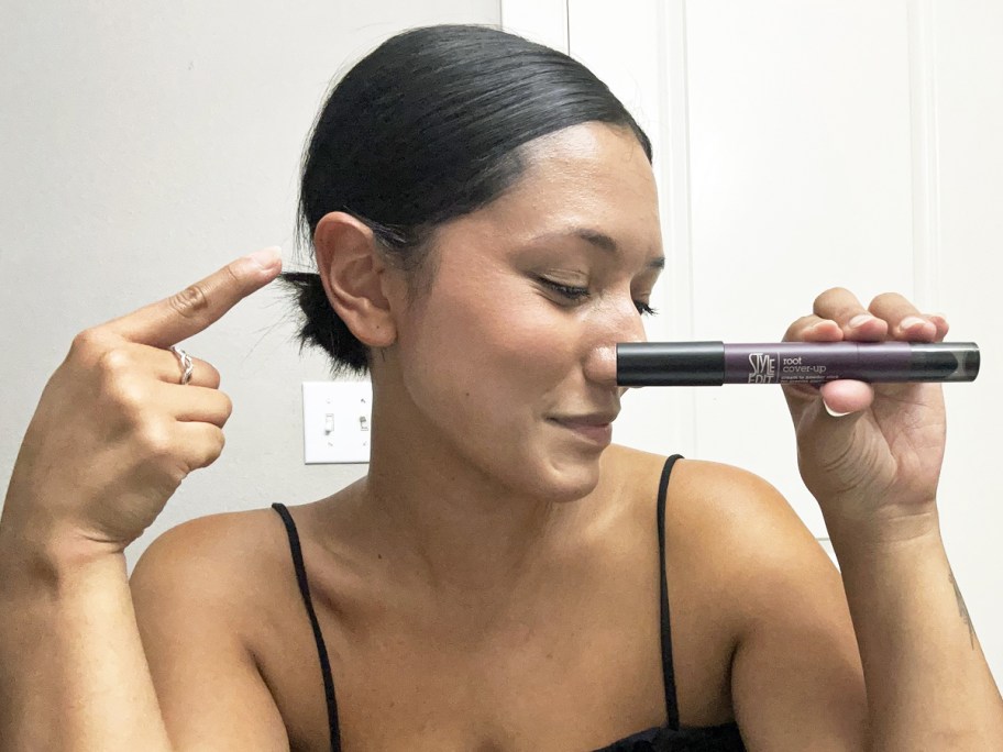 woman pointing to her hair and holding up Style Edit Root Cover-Up Stick