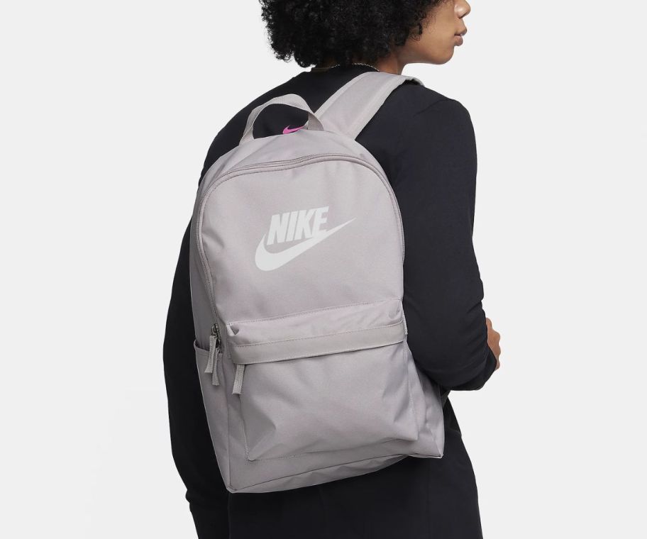 a id wearing a gray nike backpack