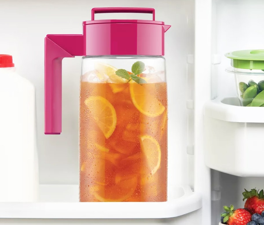 drink pitcher with pink lid and handle on door of fridge