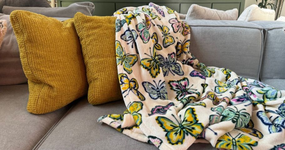 A couch with a The Big One Butterfly Print Throw on it