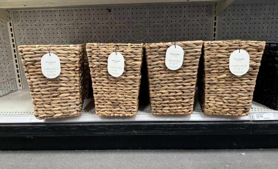 four rattan woven waste baskets on a store shelf