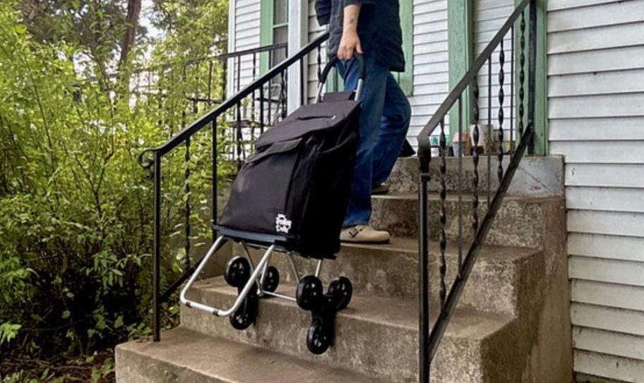 a woman rolling a trolley dolly up the front steps of a house