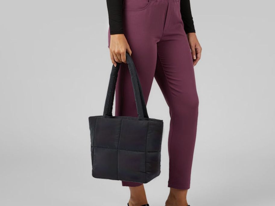 Woman holding puffer purse in black