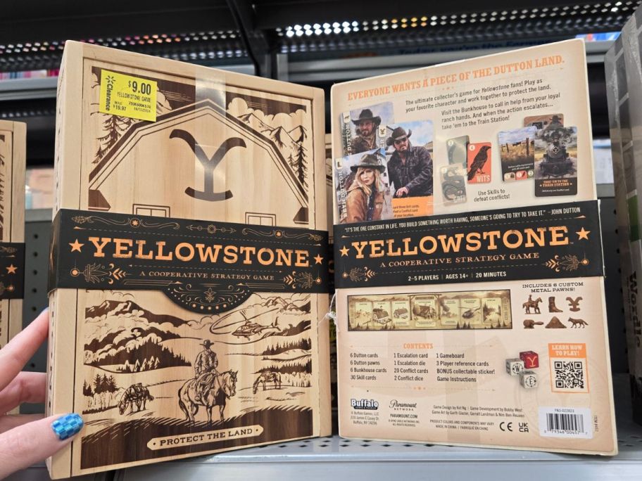 A hand holding a Yellowstone Board Game