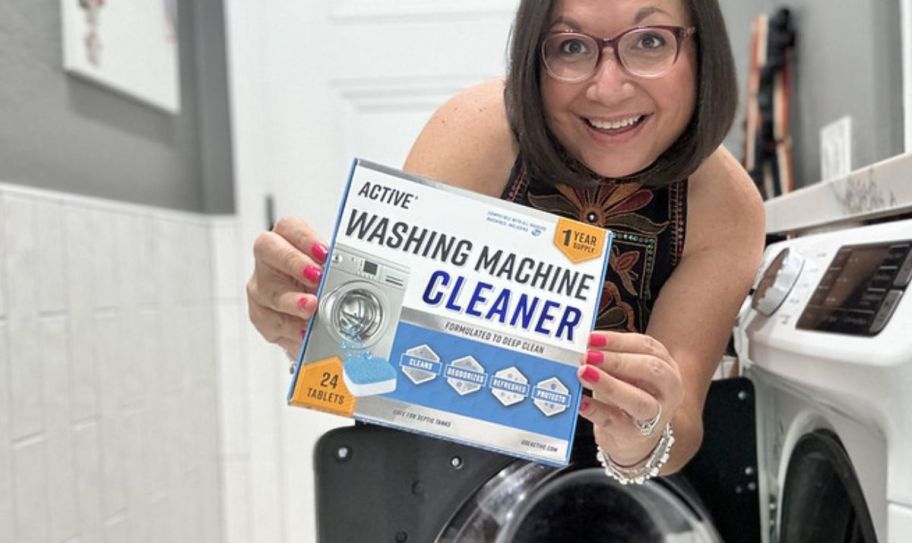 a woman holding a box of Active Washing Machine Cleaner and smiling